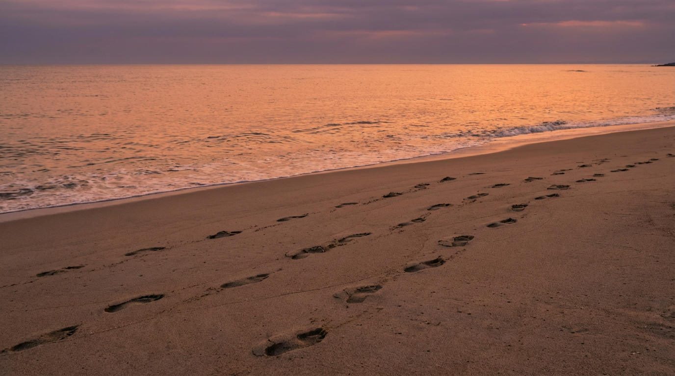夕暮れの海と波打ち際の足跡。人物は写らない。複数の自分を抱えたまま進む静かな風景